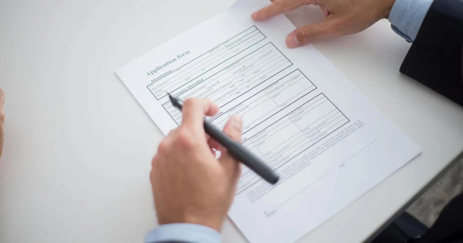 Applicant reviewing a permit application form at a desk.