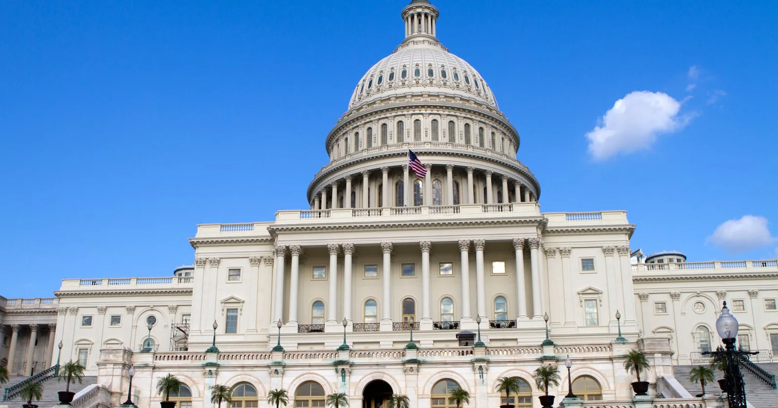 The United States Capitol building in Washington, DC, seen from the west front under a clear blue sky.