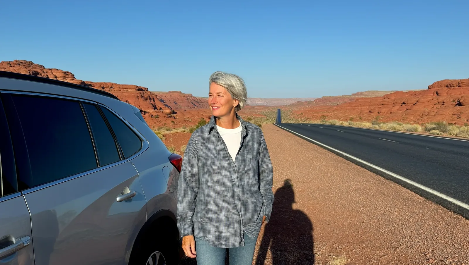 Woman beside her SUV on a desert highway