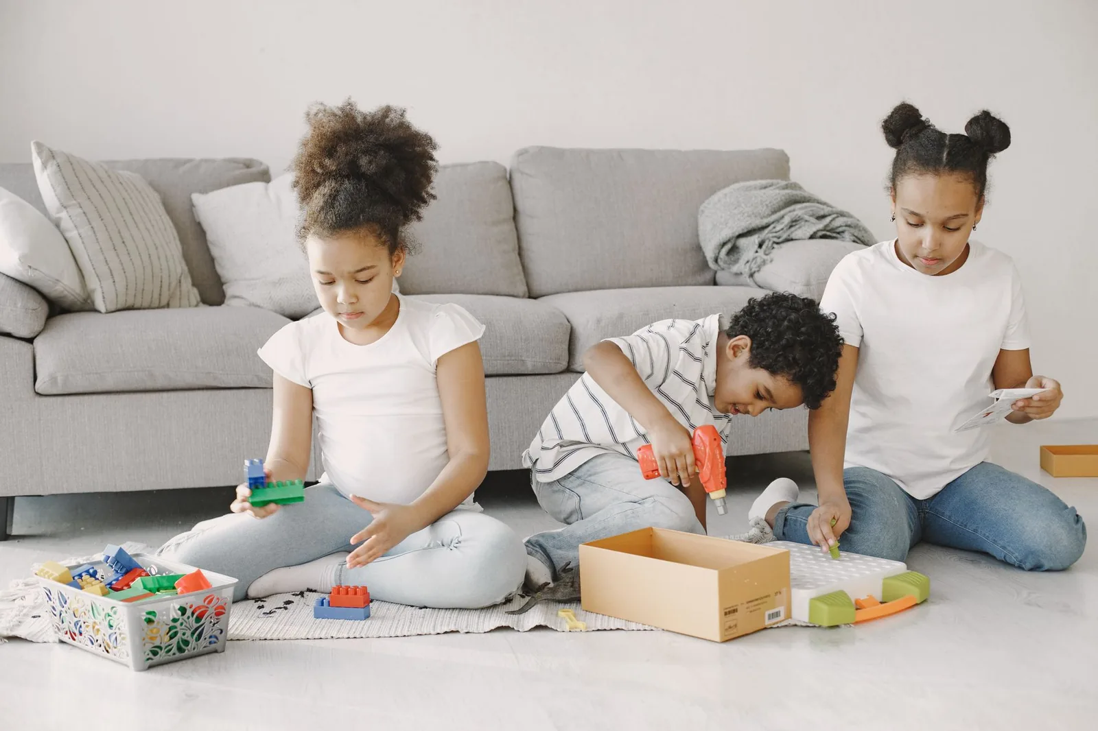Three children playing with toys in a living room